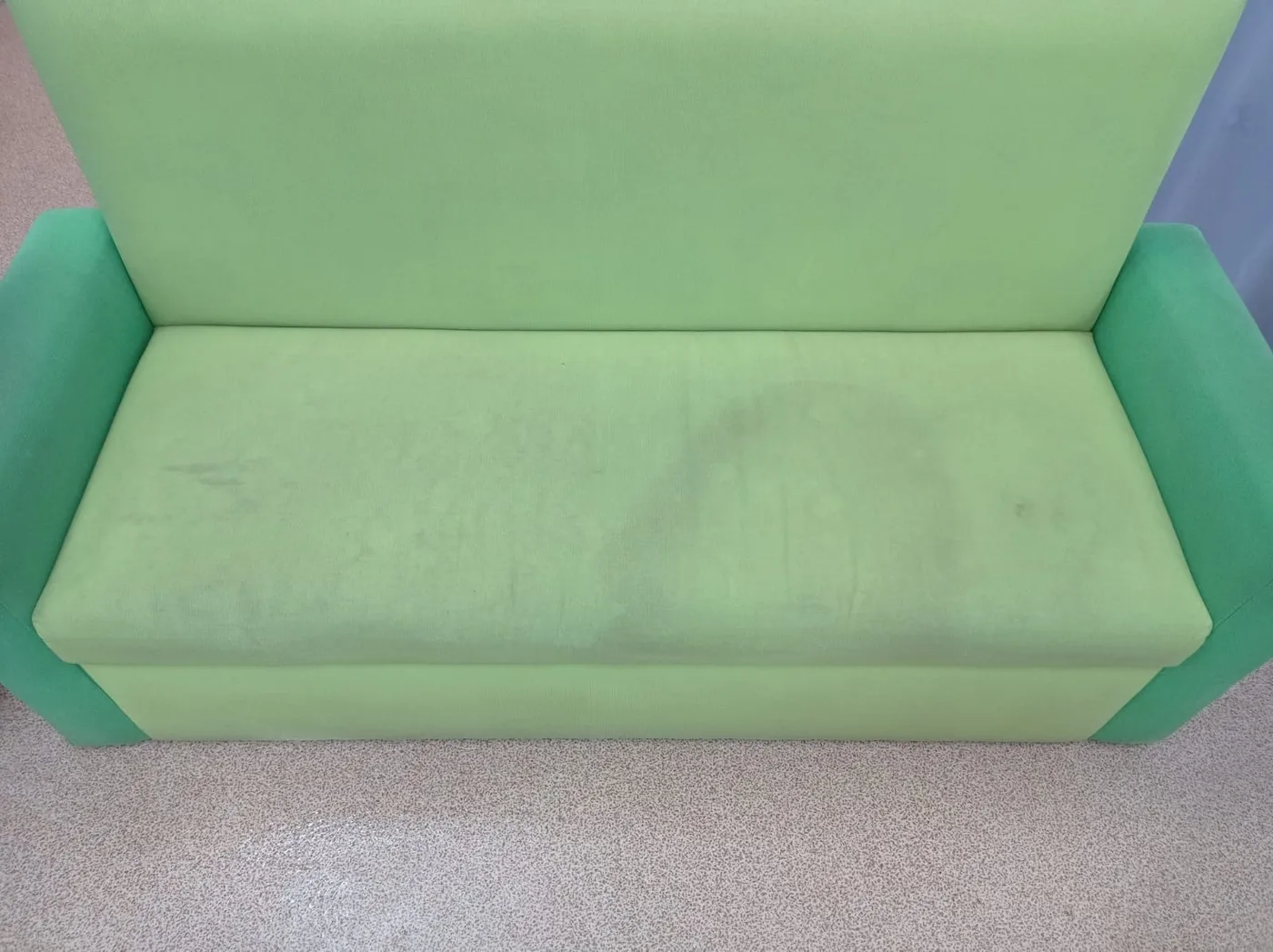 Grünes Sofa in Bielefeld vor der schonenden Reinigung — sichtbare Flecken