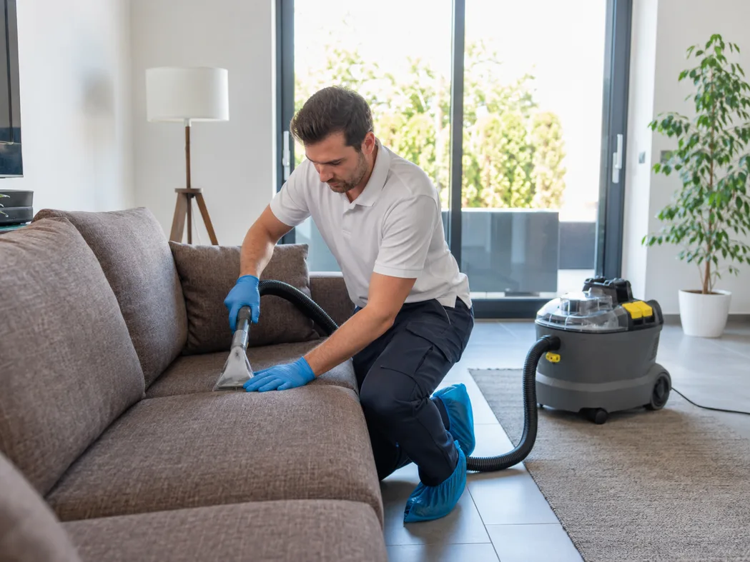 Realistische Erwartungen bei Milbenreduktion — Hygrometer mit Anzeige bei 50 % Luftfeuchtigkeit, sauberes Sofa im Hintergrund